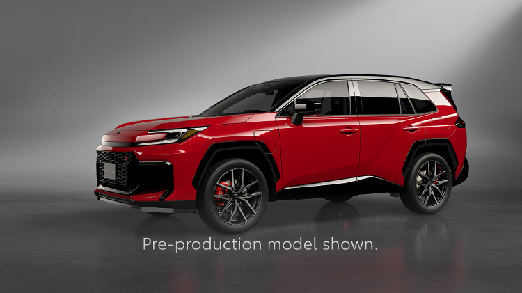 A RAV4 in Feverish Red paint is displayed in a studio with soft grey lighting. The SUV features a bold front grille, sporty wheels, and red brake calipers. Text at the bottom reads, Pre-production models shown.