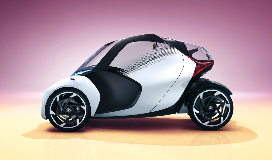 A futuristic, single set, black and silver Toyota concept vehicle with three wheels.