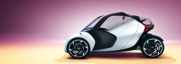 A futuristic, single set, black and silver Toyota concept vehicle with three wheels.