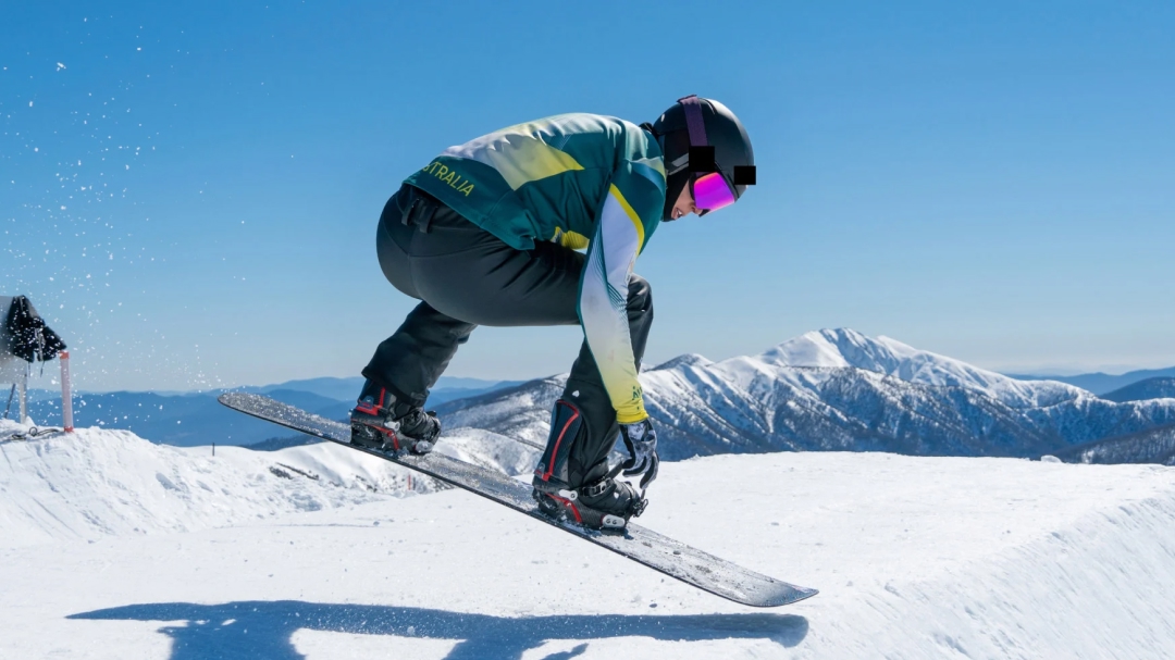 Australian Olympian snowboarder Belle Brockhoff, in a mid-air jump while snowboarding down a mountain.