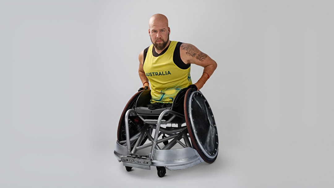 Australian Paralympian wheelchair rugby player Ryley Batt sitting imposingly in his Australian Olympic uniform and his rugby wheelchair.