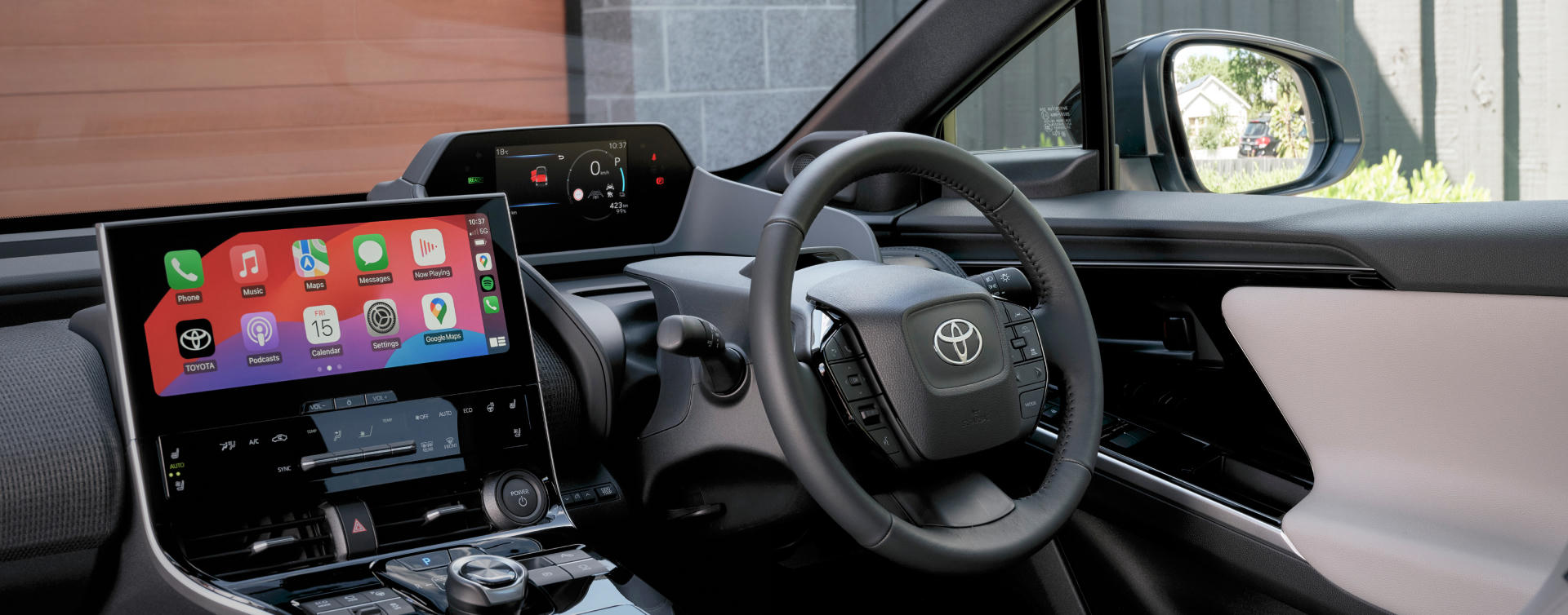 Modern interior of a Toyota, featuring a glossy digital centre console touchscreen, steering wheel and fully digital heads up display.