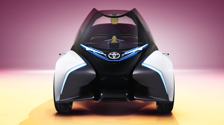 A futuristic Toyota concept car with a sleek, aerodynamic design and blue LED lighting.