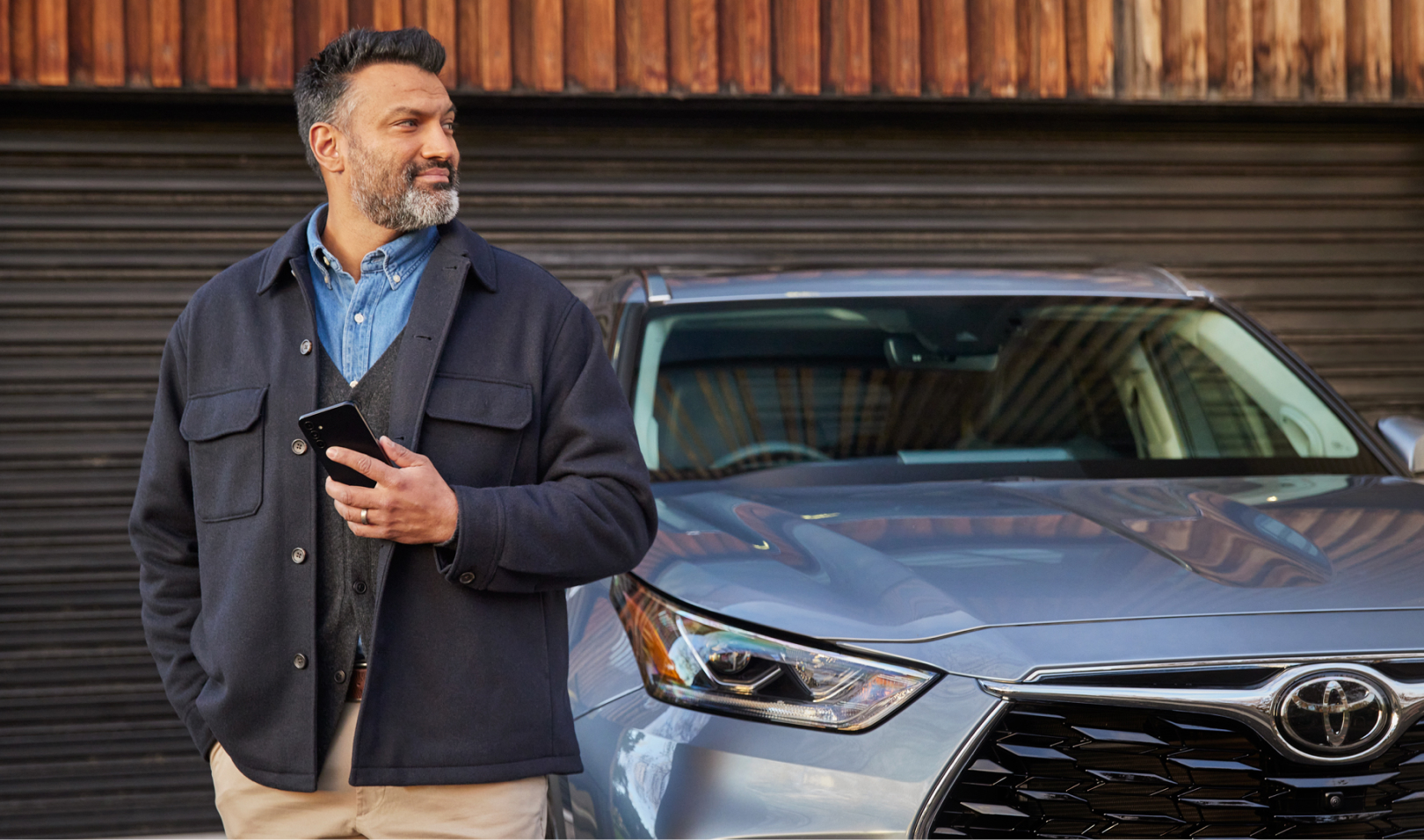 The rear center console of a Toyota, featuring a touchscreen display for climate and seat controls, and a leather armrest.