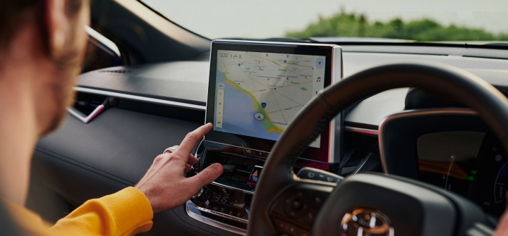 A man operating the multimedia unit inside his Toyota passenger car.